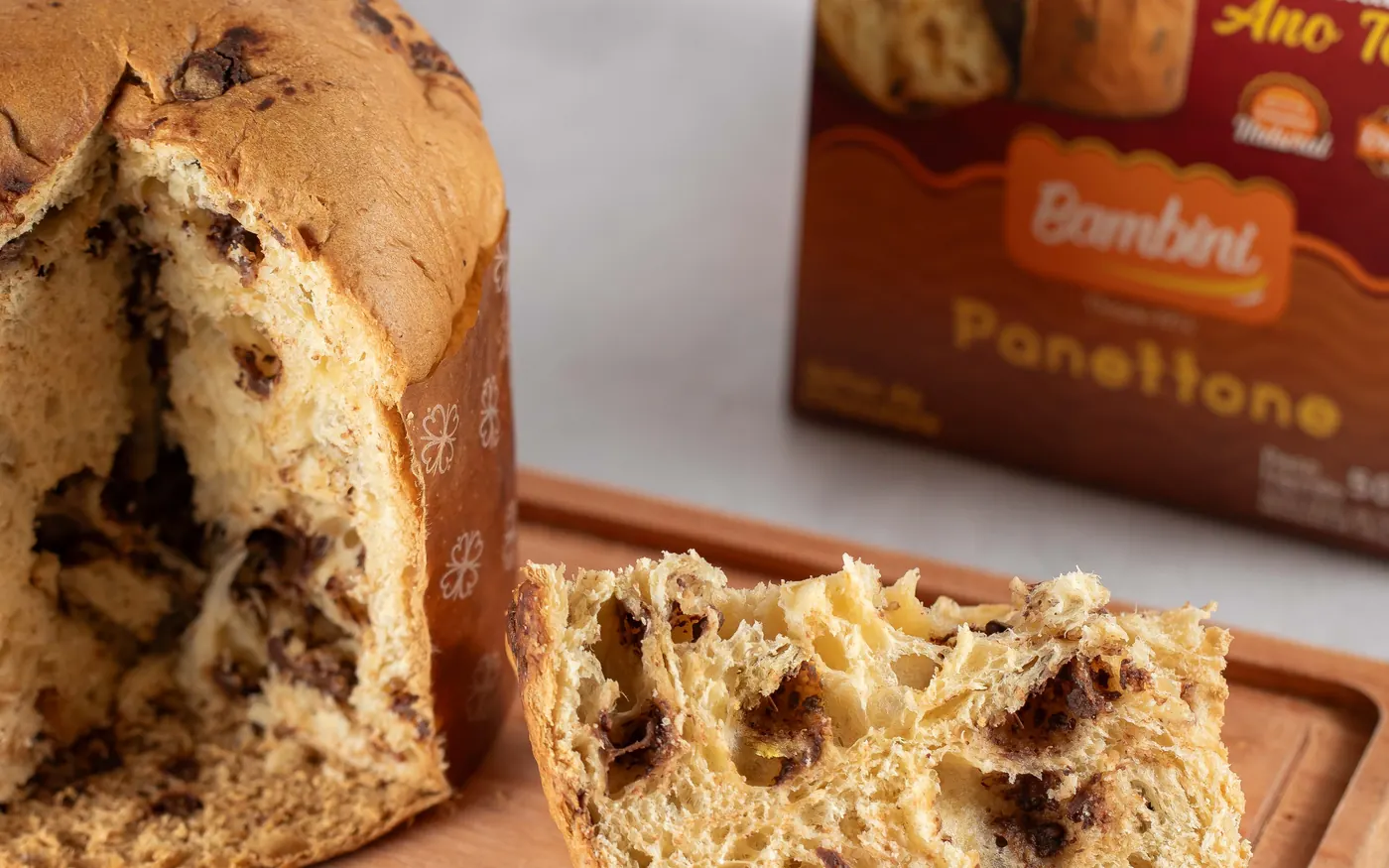 Panettone Bambini de gotas sabor chocolate aberto sobre tábua, ao lado da caixa
